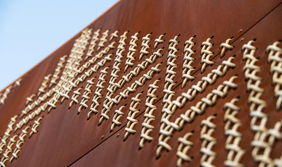 A visually impactful addition, and one deep with meaning, are the circular walls featuring the largest tukutuku panels in the world. Tukutuku was used by Māori to bind materials for houses and the same techniques were used to bind waka that navigated to Aotearoa New Zealand. The tukutuku designs incorporate kaokao, poutama, roimata tōroa, pātiki and patterns specific to Te Poho o Rāwiri Marae
One hundred and twelve steel tukutuku panels, punched with 53,900 individual holes were woven with 7.3km of cord by volunteers from local iwi Ngāti Oneone and skilled weavers from around Tairawhiti.
