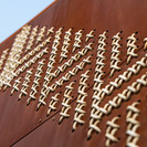 A visually impactful addition, and one deep with meaning, are the circular walls featuring the largest tukutuku panels in the world. Tukutuku was used by Māori to bind materials for houses and the same techniques were used to bind waka that navigated to Aotearoa New Zealand. The tukutuku designs incorporate kaokao, poutama, roimata tōroa, pātiki and patterns specific to Te Poho o Rāwiri Marae
One hundred and twelve steel tukutuku panels, punched with 53,900 individual holes were woven with 7.3km of cord by volunteers from local iwi Ngāti Oneone and skilled weavers from around Tairawhiti.