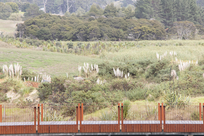 Side view of corten balustrade slats disappearing into the landscape behind it_