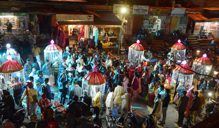 Just outside the walls of Jaisalmer in Rajasthan shows a Hindu wedding procession in full swing, with the groom mounted on a white horse.