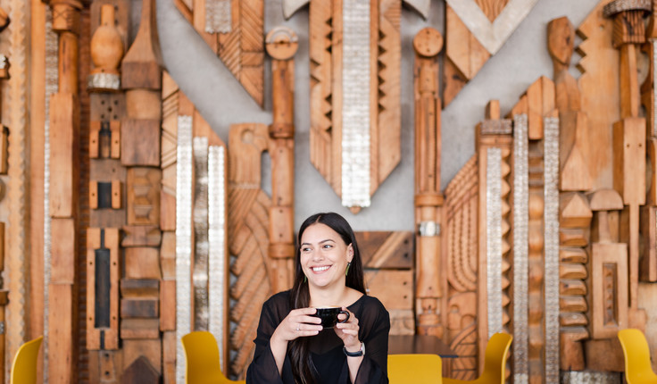 Image: uploads/2020_10/Smiling_girl_holding_a_cup_of_coffee_in_Box_Cafe_in_Auckland_with_wooden_2HVesKc.jpg